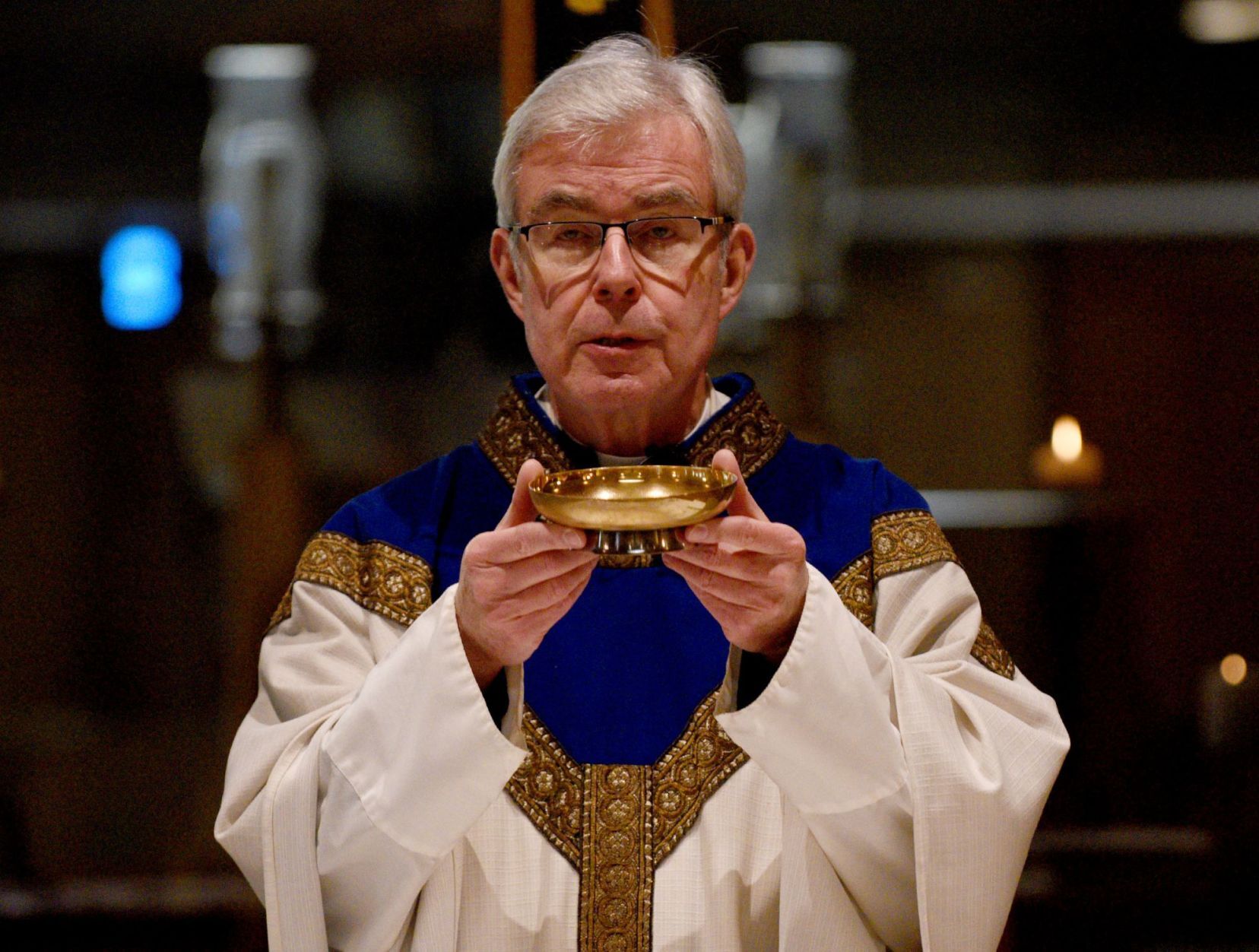The Rev. Jerome Day blesses the bread